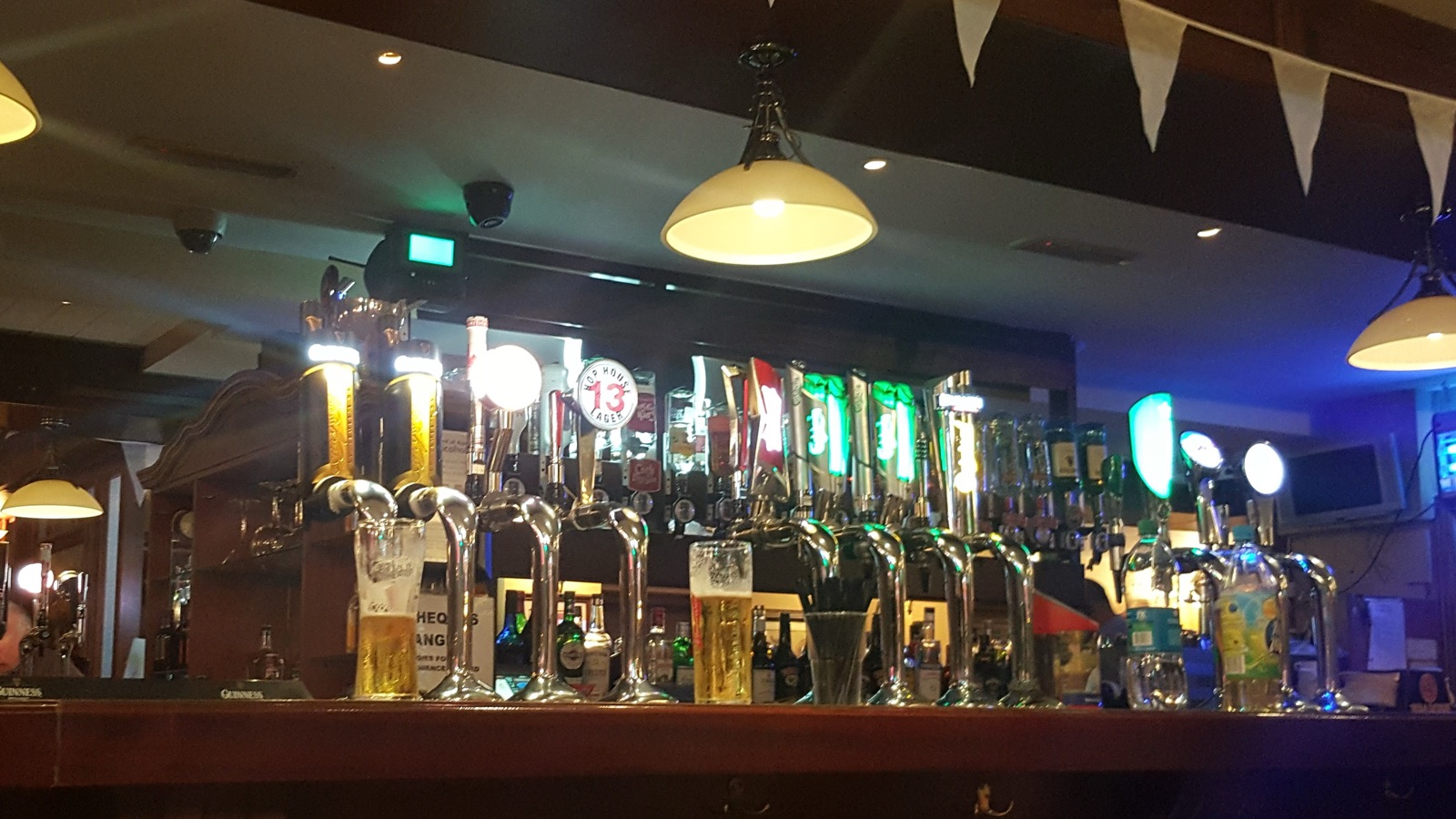 The bar at Jones’: beer taps glowing under pendant lamps along the dark-wood counter